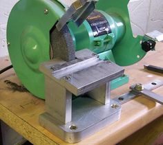 a machine that is sitting on top of a wooden table next to some scissors and other tools