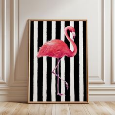 a pink flamingo standing in front of a black and white striped background on a wooden frame