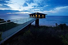 a glass walkway leading to the beach at night