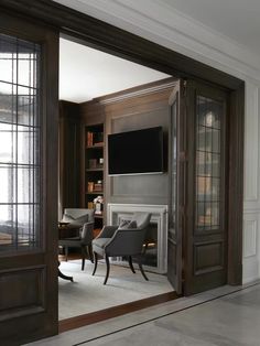 a living room filled with furniture and a flat screen tv mounted on a wall above a fireplace