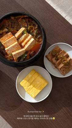 there are three plates with food on the table next to each other and one plate has two pieces of bread