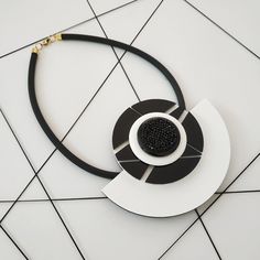 "A beautifull combination of black and white lines with black swarovski crystals in the center. A unique and sophisticated necklace that will upgrade any elegant outfit! Share with the world your exquisite taste! Lightweight necklace. * * * * * * * * * * * Materials: 0.24\"/6m\" thick black silicon cord 0.12\"/3m\"m thick plexiglass Swarovsky crystals resin acrylic colors Bib: height: 4.13\"/10.5c\"m width: 5.12\"/13c\"m max. thickness in circle center: 0.9\"/2.3c\"m Check out shop's Clip On Ear Elegant White Necklace, Resin Acrylic, Crystal Resin, Black And White Lines, Gold Statement Necklace, Bib Necklaces, Clay Necklace, Geometric Necklace, Black Necklace