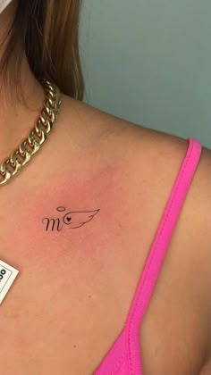 a woman with a tattoo on her chest and name tag in front of her shoulder