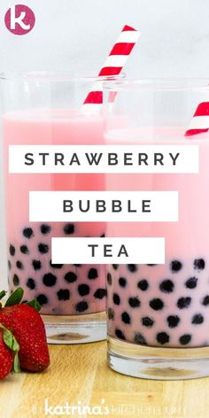 two glasses filled with strawberry bubble tea and strawberries next to each other on a wooden table