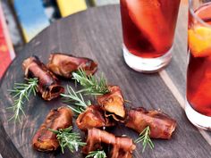 bacon wrapped in rosemary next to two glasses of tea