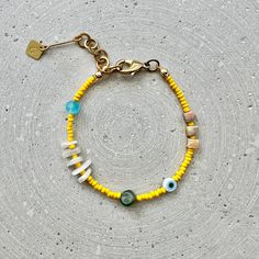 Colorful narrow bead bracelet with agate cubes, moonstone and jade nuggets, as well as yellow and turquoise glass beads and an Evil Eye charm. Perfect for your beach outfit! Matching earrings are also available for this bracelet: https://www.etsy.com/listing/1475446457 LENGTH The total length is approx. 20cm/7.8" and fits best on wrists between 16-18cm/6.3" to 7" thanks to the extension chain. If you need a different length, simply select the "custom length" option in the menu and specify your w Yellow Letter Beads Jewelry For Beach, Yellow Beaded Bracelets With Colorful Beads For Beach, Colorful Beaded Bracelets For The Beach, Yellow Beaded Bracelets For Beach With Colorful Beads, Adjustable Yellow Beaded Bracelets With Natural Stones, Natural Stone Beads Bracelet For Beach, Bohemian Yellow Letter Beads, Yellow Bohemian Letter Beads, Yellow Beaded Bracelets For The Beach