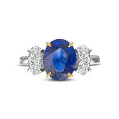 a blue sapphire and diamond ring with three diamonds on the side, set in white gold