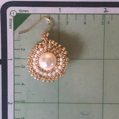 a pair of earrings sitting on top of a ruler