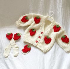 a knitted sweater and booties with strawberries on them