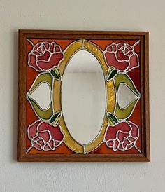 a mirror mounted to the side of a wall next to a flowered design on it