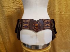 Beautifully crafted leather utility belt, handmade with love. This belt was created with a dark brown base leather, earthy purple and gradients of maroon accent leather, and antique brass hardware. A large fiery tiger's eye stone is set into the leather in the center of the back of the belt. At each hip, there are spacious pockets large enough to hold all you may need to carry. One one side is one larger pocket, and on the other is two smaller pockets. Original design, one of a kind, made to ord Earthy Purple, Leather Utility Belt, Biker Gear, Utility Belt, Antique Brass Hardware, Green Copper, Tiger Eye Stone, Eye Stone, Suspender Belt