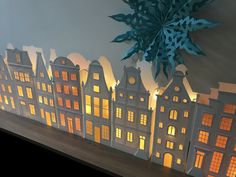 a paper cut out of buildings with lights on them