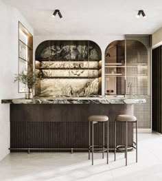 two stools are in front of a bar that is decorated with marble and wood