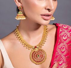 HAND CRAFTED JEWELLERY DESCRIPTION *Gold plated temple jewellery set *Gold plated necklace, has an embellished circular centrepiece, secured with drawstring fastening *A pair of embellished gold plated jhumka earrings, has a floral base, a dome-shaped dangler and pearl-like beaded drops *Secured with a post-and-back closure *Size:- Length of the necklace: 16 cm Length of the earrings: 5 cm *Material:- Material: Brass Plating: 24K gold-plated *Care:- Wipe with a clean cotton swab when needed NOTE All the raw material used in this product is of high quality and is handcrafted with love. Premium Quality and High craftsmanship 100% Satisfaction Guarantee: Long Lasting Plating, High-Quality Stones. Our jewellery is individually handcrafted by master artisans using meticulous crafting techniques Indian Long Necklace, Stone Temple, Rani Haar, Temple Jewelry, Polki Necklace, Cotton Swab, Jewelry Indian, Clean Cotton, Jhumka Earrings