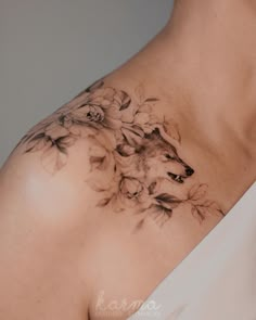 a woman's chest with flowers and a wolf on it