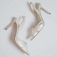 two pairs of white high heel shoes with pearls on the toes and heels are shown