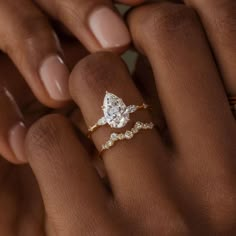 a woman's hand holding a diamond ring with two diamonds on the middle finger