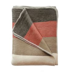 a blanket that is folded up on top of a white surface with an orange and grey stripe