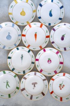 a bunch of plates that have different designs on them, all in different colors and sizes