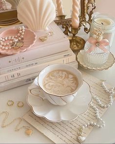 a cup of coffee sitting on top of a saucer next to a stack of books