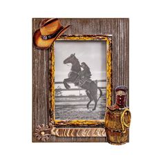 an old photo frame with a cowboy riding a horse and a bottle next to it