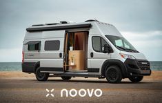 an rv parked on the beach with its doors open