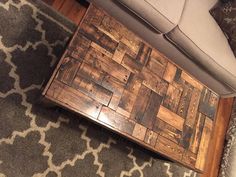 a wooden table sitting on top of a rug next to a couch