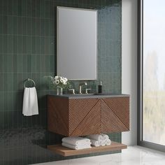 a bathroom with green tiled walls and white towels on the counter next to a mirror