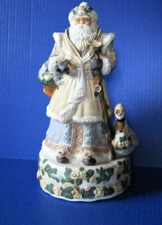 a ceramic figurine of an old man and two dogs on a blue background