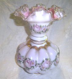 a white vase with pink roses on it