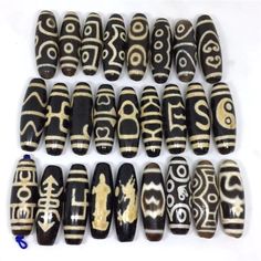 an assortment of black and white beads with gold designs on the top, along with other bead patterns