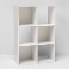 a white bookcase with four sections on each side and one section missing from the other