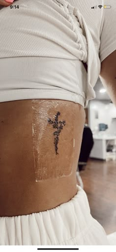 a person with a cross tattoo on their stomach and the bottom half of her body