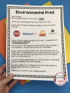 a hand holding up a paper with the words environmental print on it and four different colored papers