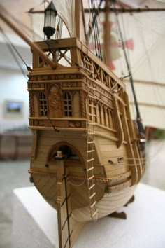 a wooden model of a pirate ship on display in a room with white walls and flooring