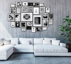 a large white couch sitting in front of a wall with pictures on it's side