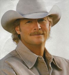 a man in a cowboy hat poses for a photo