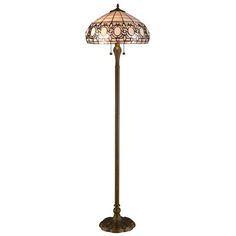 a floor lamp with a stained glass shade on the top and bottom, in an antique brass finish