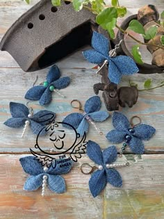 some blue flowers are sitting on a wooden table next to a birdhouse and keychain