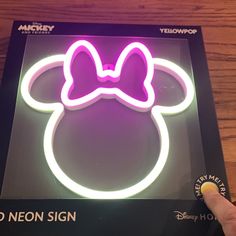 a neon sign with a minnie mouse head on it's face is being held up by a hand