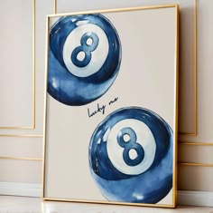 two blue and white pool balls with the number eight on them in front of a beige wall