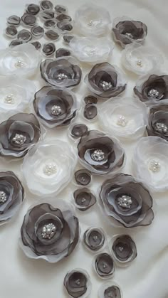 a bunch of flowers that are sitting on a table cloth with pearls in the center