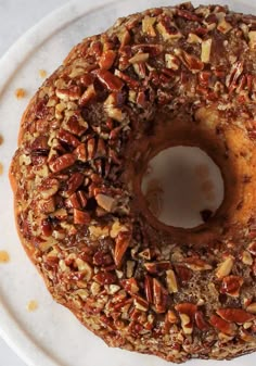 a bundt cake covered in nuts on a white plate