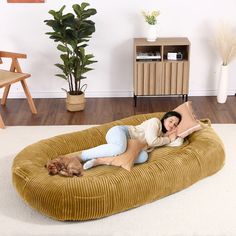 a woman laying on top of a dog bed in the middle of a living room