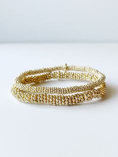 two gold bead bracelets Gold Wrap Bracelet With Tiny Beads As A Gift, Gold Wrap Bracelet With Spacer Beads As Gift, Gold Hand-strung Wrap Bracelet Gift, Dainty Hand Wrapped Gold Beaded Bracelets, Dainty Hand-wrapped Gold Beaded Bracelets, Gold Beaded Bracelets For Layering, Gold Wrap Bracelet For Layering, Elegant Gold Stretch Bracelet Stackable, Adjustable Gold Stretch Bracelet Stackable