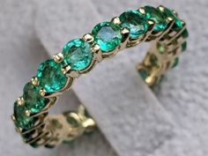 an image of a ring with green stones on it