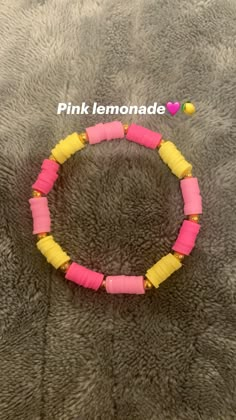 the pink lemonade bracelet is made with yellow and pink plastic beads on a gray background