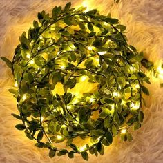 a wreath with lights on it sitting on a rug