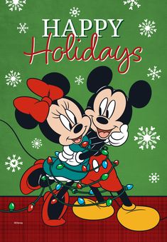 two mickey mouses hugging each other in front of a christmas card