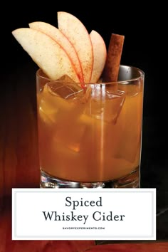 spiced whiskey cider with apple slices and cinnamon sticks